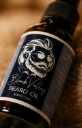 A collage showing beard oil bottles: a close-up of a dark amber bottle with a black cap and a black label featuring a white illustrated beard and sunglasses, plus two wider scenes with several matching bottles on a wooden surface and a hand reaching for one bottle.